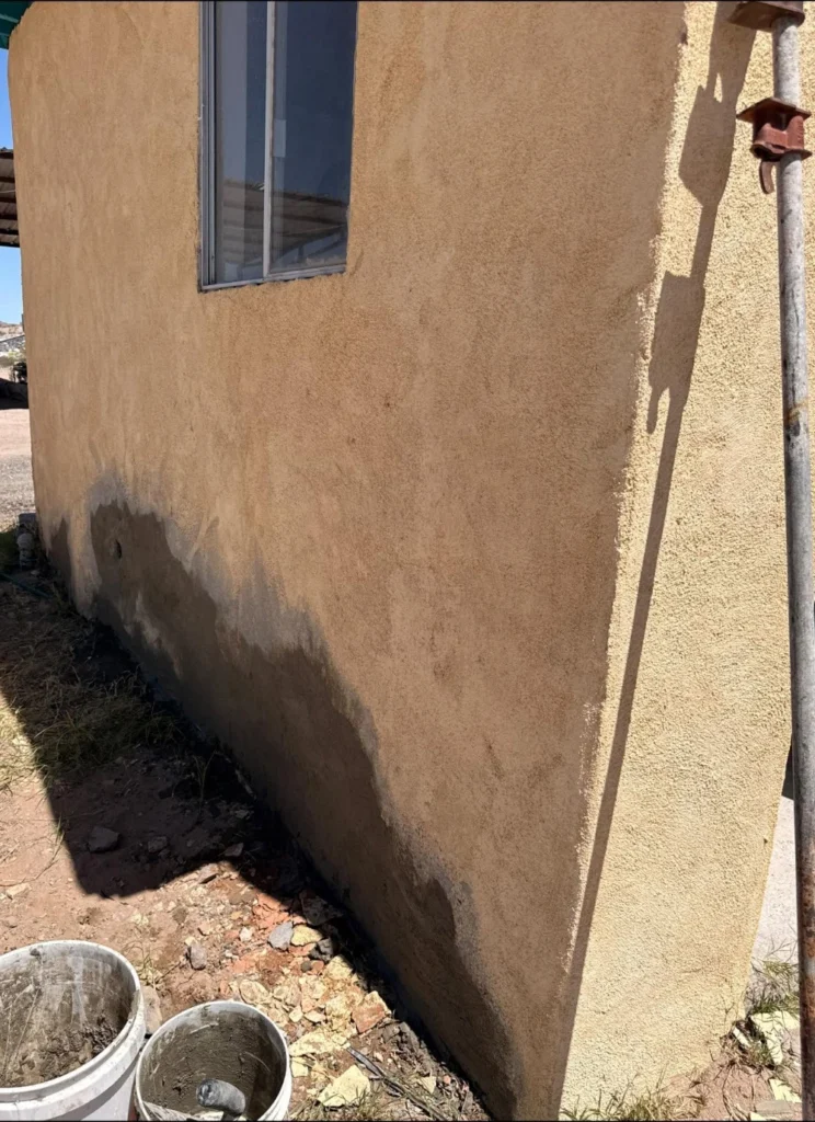 Water staining at the base of a stucco wall on a Las Cruces home